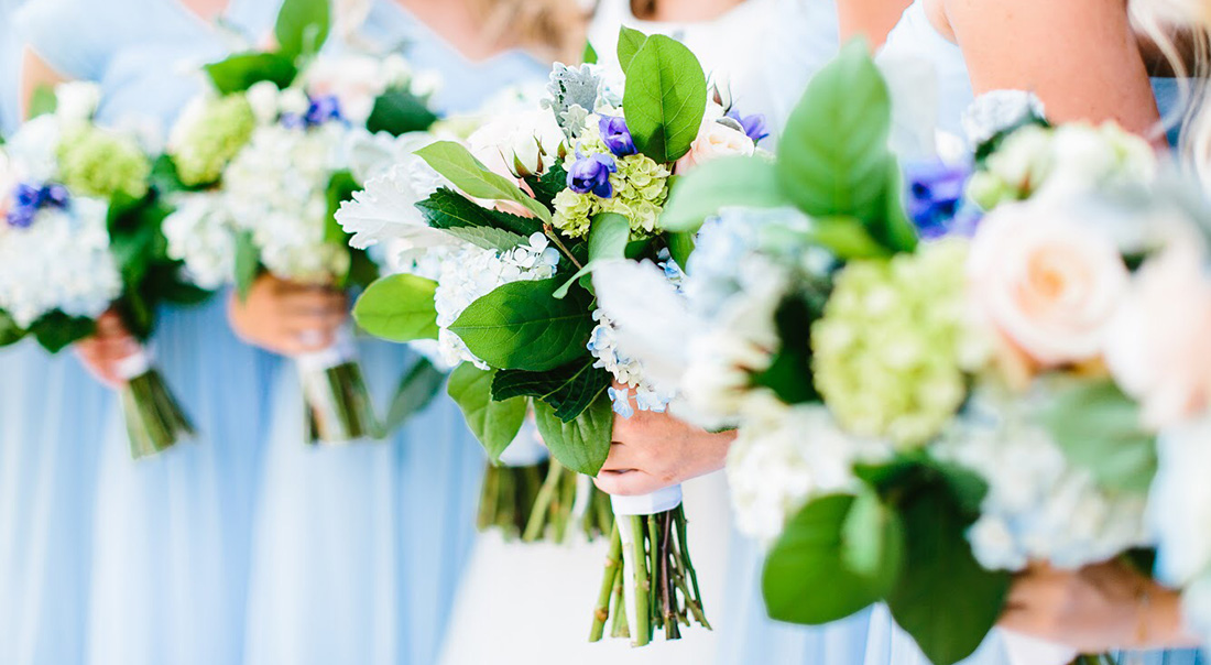 A close up shot of a bridal party's leafy green bouquets